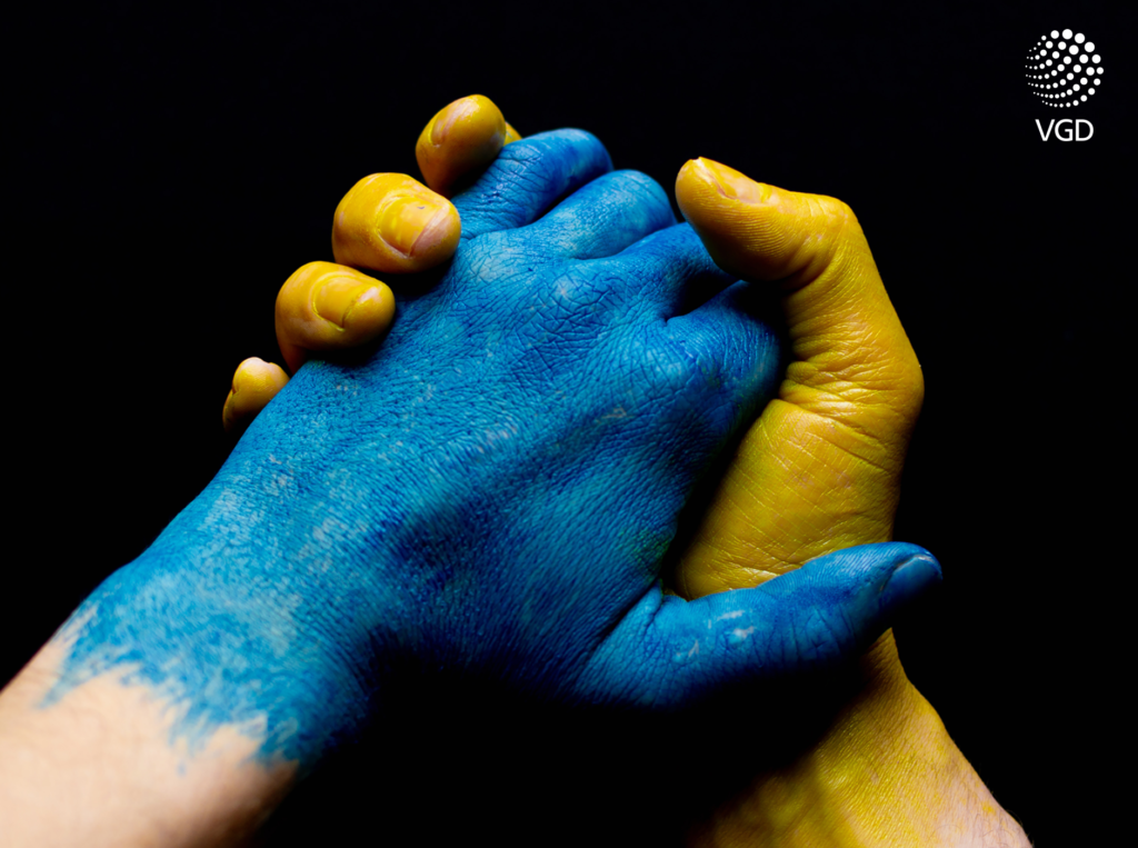 niebieska i żółta dłoń w uścisku tworzące flagę Ukrainy