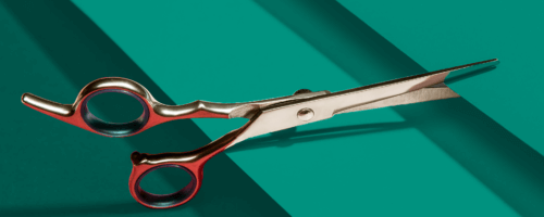 scissors cutting a cyan sheet of paper